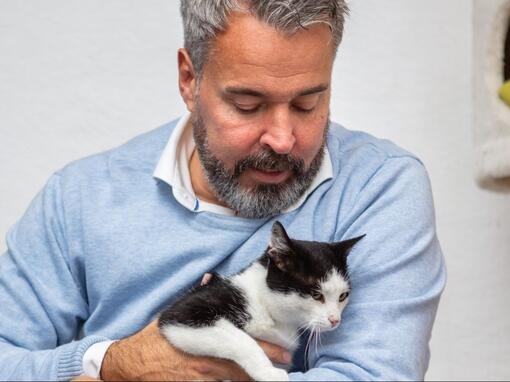 Mann holder katt i armene